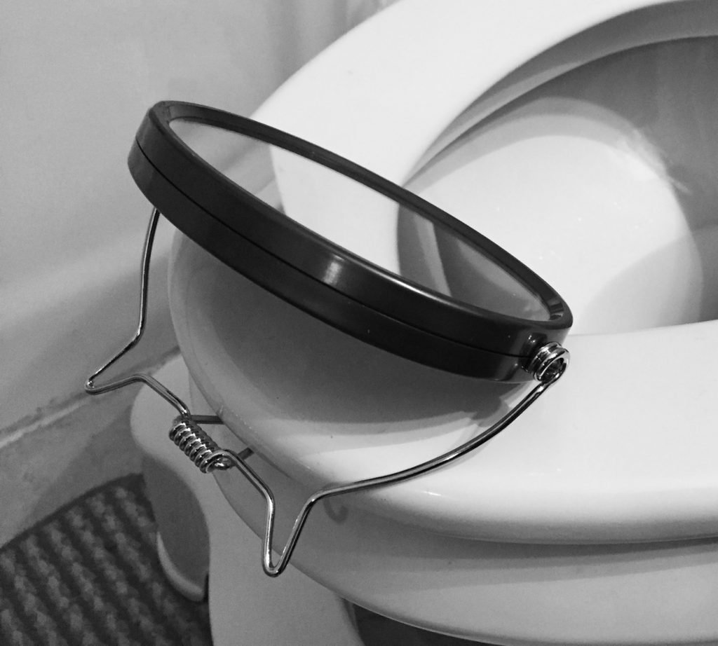 mirror hooked on toilet seat for catheterization