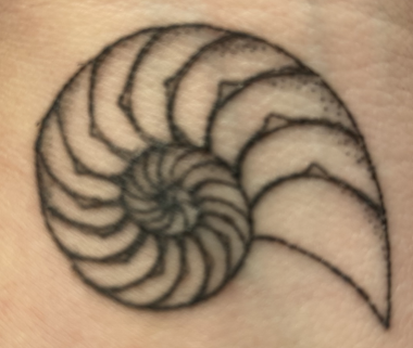 Close-up photo of Jamie's black chambered nautilus tattoo.