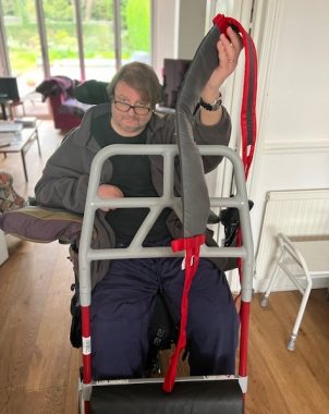 Molift | Multiple Sclerosis News Today | John holds up a new Molift strap with his left hand 
