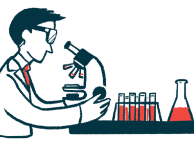 A researcher looks through a microscope in a lab, alongside a rack of test tubes and a vial all filled with liquid.