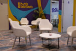 An image of chairs and a table grouped together with the EMD Serono logo in the background at the ACTRIMS conference.