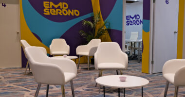 chairs and a table with the EMD Serono logo in background at ACTRIMS conference