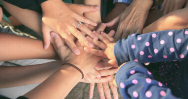 Hands placed on top of each other in solidarity