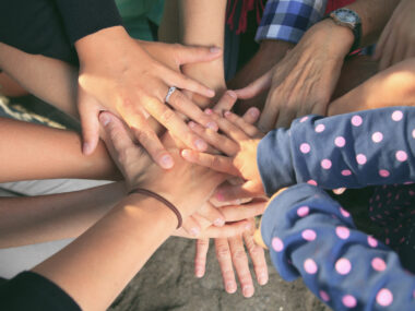 Hands placed on top of each other in solidarity