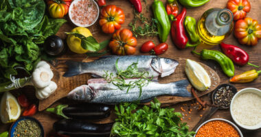 A variety of foods, including fish, leafy greens, tomatoes, garlic, and peppers.
