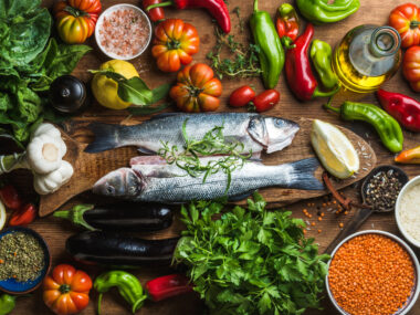 A variety of foods, including fish, leafy greens, tomatoes, garlic, and peppers.
