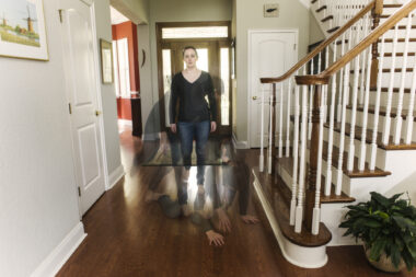 A photo of a woman standing still in her home is overlaid with semi-opaque images of her falling to the ground.