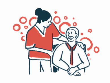 A nurse puts an arm around an older man seated in a chair.