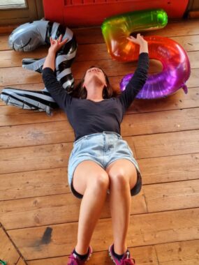 Ena Salcinovic lies on a floor below inflated balloons of a "3" and a "5."