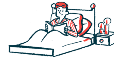 A person in pajamas sits in a bed reading a book.