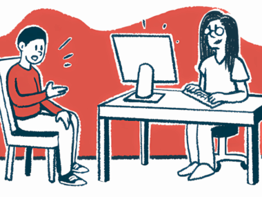 A patient sits with a doctor who is working at a computer.