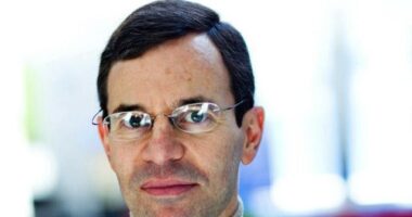 A headshot shows a man with dark hair and glasses.