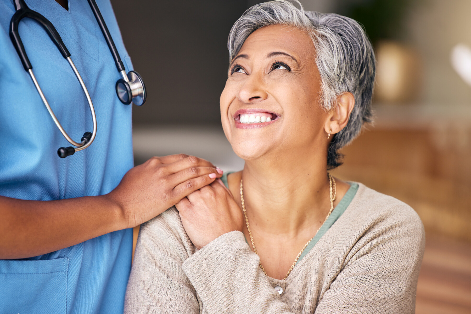 A smiling patient is being comforted by a doctor.