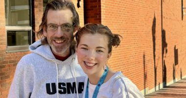 A man and his daughter smile for a photo.