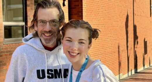A man and his daughter smile for a photo.