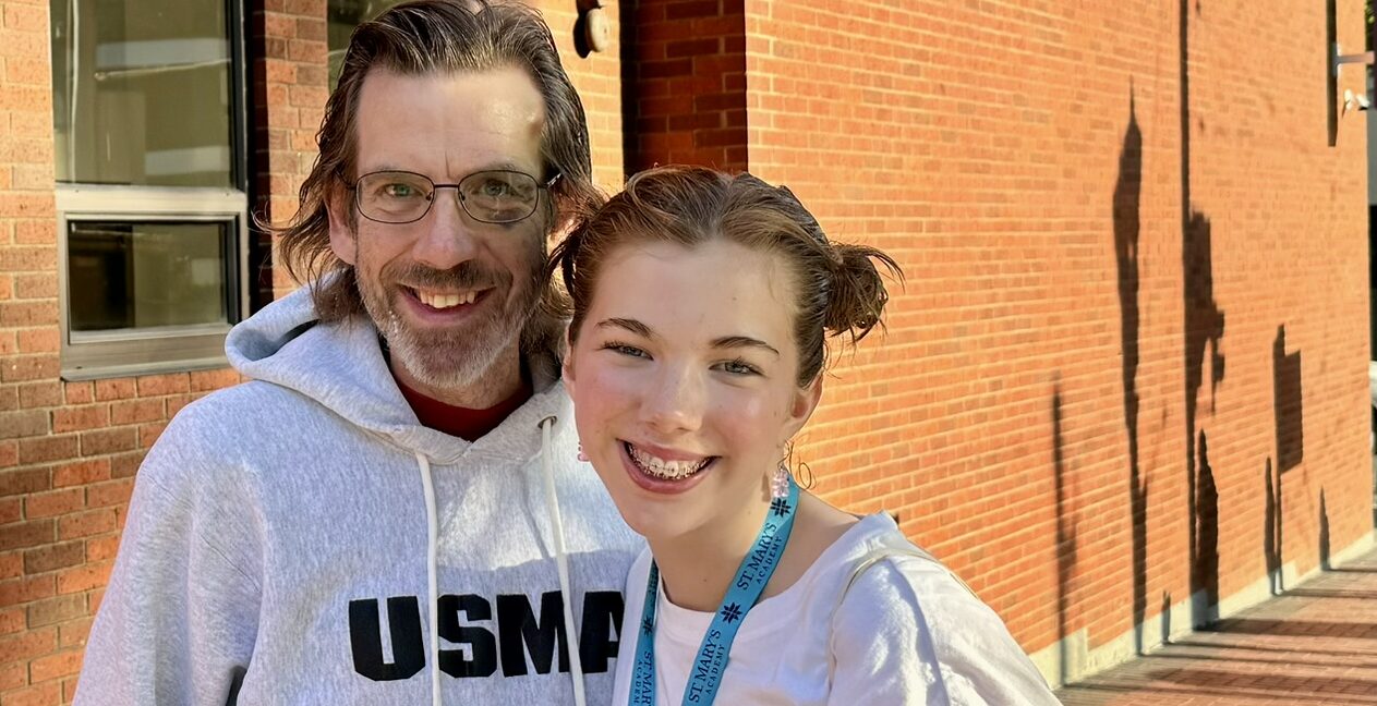 A man and his daughter smile for a photo.
