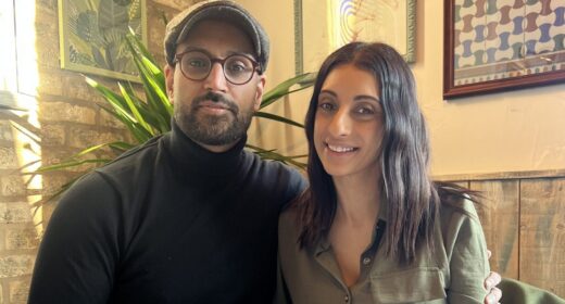 A couple (man and woman) sit together at a dinner table.