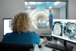 Close-up rear view of a female technician during an MRI scanning procedure,