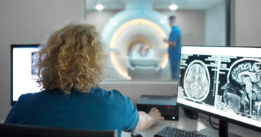 Close-up rear view of a female technician during an MRI scanning procedure,