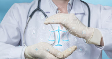 An image of a scale is superimposed over cupped hands of a person wearing a lab coat and stethoscope.