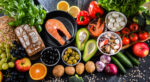 An array of foods representing the Mediterranean diet, including fish and vegetables, are shown.