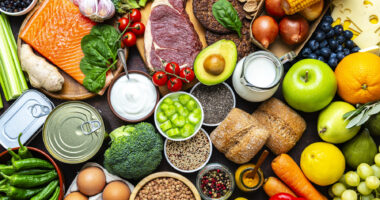 A table is filled with a variety of healthy foods including fruit and vegetables.