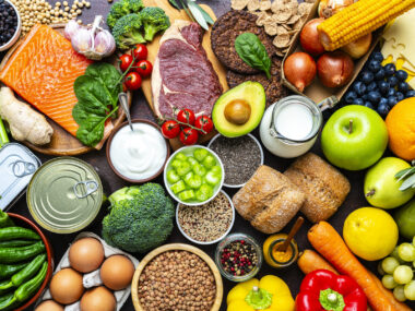 A table is filled with a variety of healthy foods including fruit and vegetables.