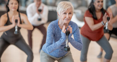 A woman with short gray hair participates in an exercise class.