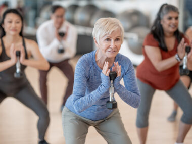 A woman with short gray hair participates in an exercise class.