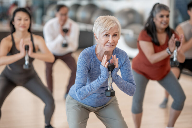 A woman with short gray hair participates in an exercise class.