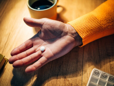 A photo shows a hand holding a pill.