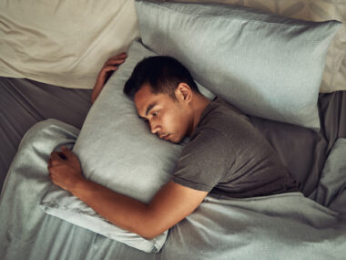 A man lies in bed fully awake.