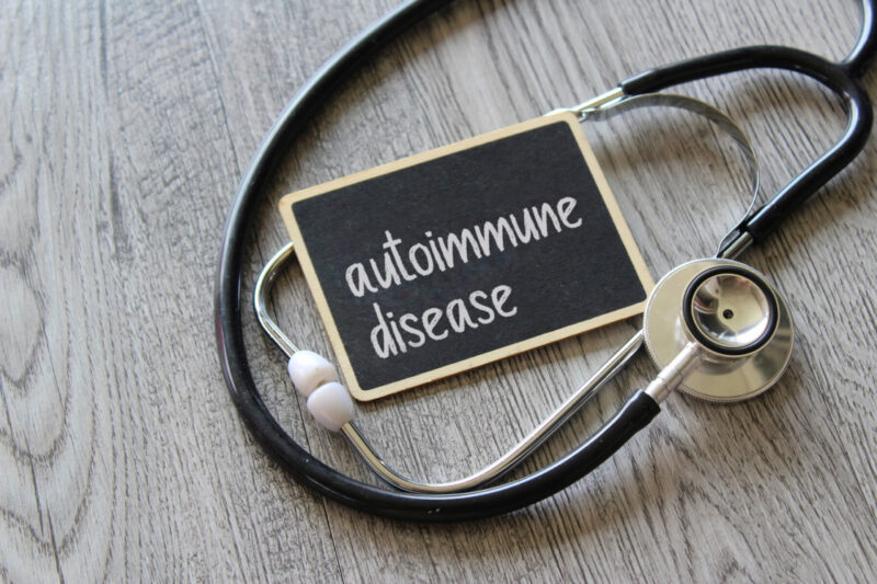 A small sign with the words "autoimmune disease' rests upon a stethoscope.