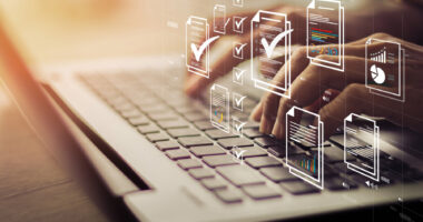 Icons showing check marks are superimposed over an image of a person's hands typing on a laptop keyboard.