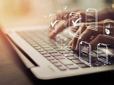 Icons showing check marks are superimposed over an image of a person's hands typing on a laptop keyboard.