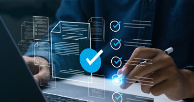 A person's hands are seen over a laptop keyboard.