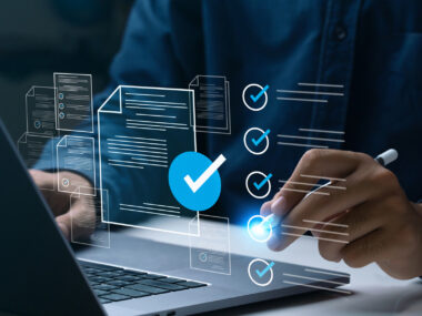 A person's hands are seen over a laptop keyboard.
