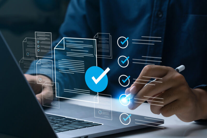 A person's hands are seen over a laptop keyboard.