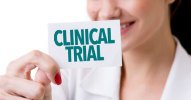 A smiling woman holds up a card with the words 