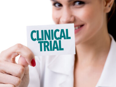 A smiling woman holds up a card with the words 