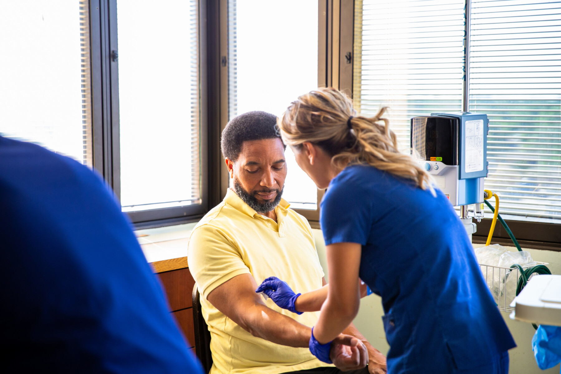 A nurse prepares to draw a man's blood for testing.