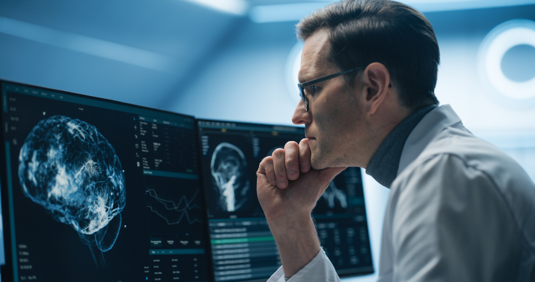 A medical professional looks at an image of a brain scan.