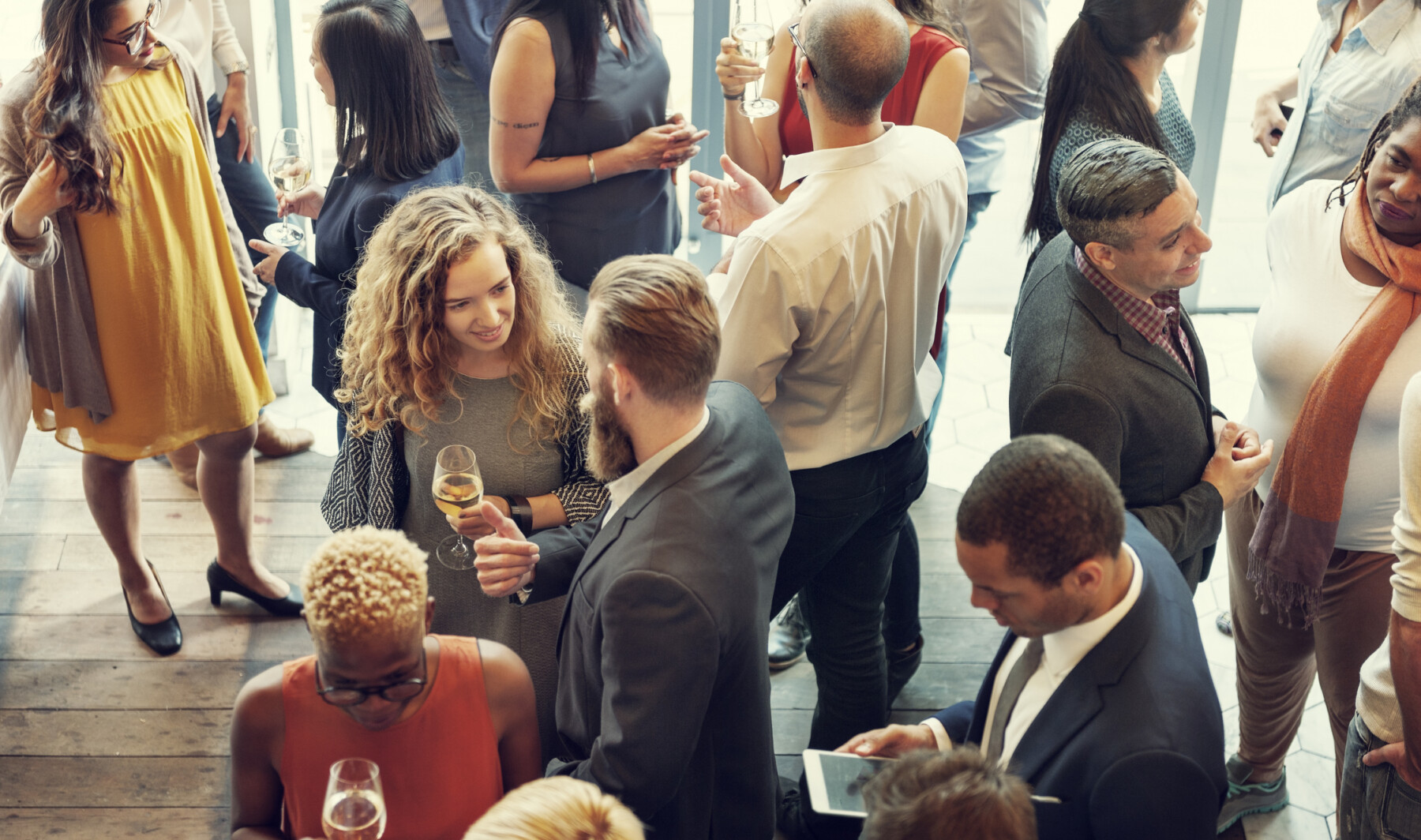 A photograph shows people mingling at a reception.
