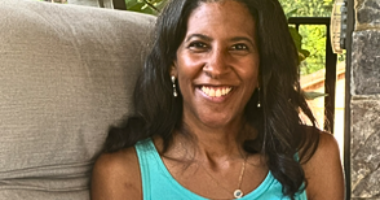 A smiling woman is pictured from the shoulders up.