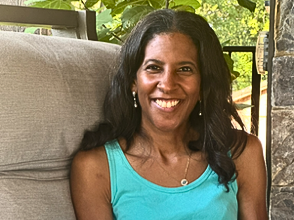 A smiling woman is pictured from the shoulders up.