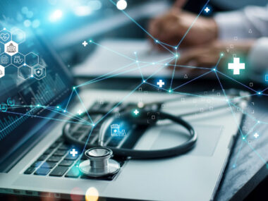 A graphic showing healthcare information is superimposed over an image of a stethoscope resting on the keyboard of an open laptop.