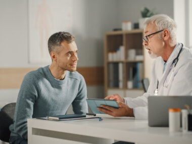 A doctor consults with a patient in their office.