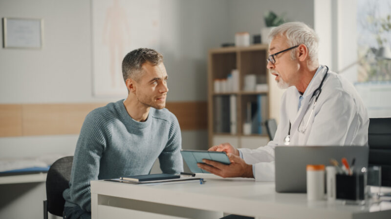 A doctor consults with a patient in their office.