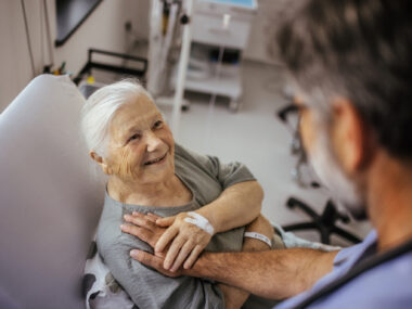 An image of an older woman talking with a healthcare professional during a medical visit.