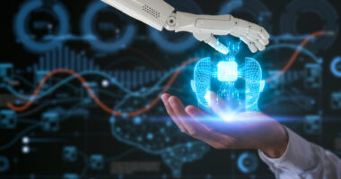 A robot hand and a human hand hold a virtual AI icon.